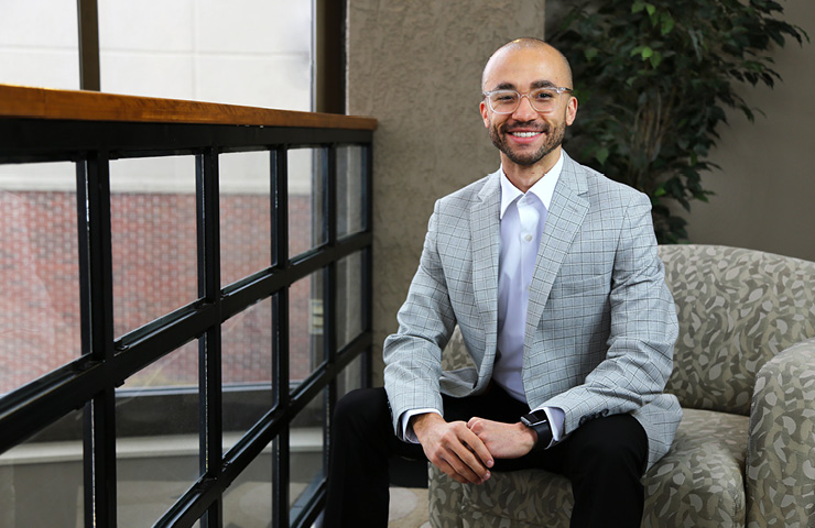 man sitting on chair in suit smiling