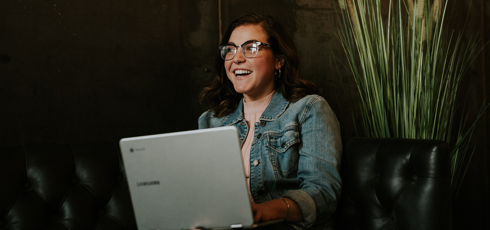 female smiling at laptop